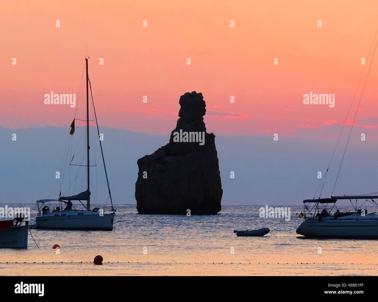 Sunset scene at Benirras beach, Ibiza Island. Rock formation and sunbeam, summer holiday scene. Stock Photo