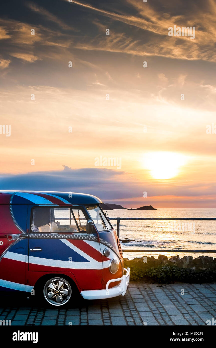 A vintage Volkswagen Camper van painted in the colours of the Union Flag parked at Little Fistral in Newquay in Cornwall. Stock Photo