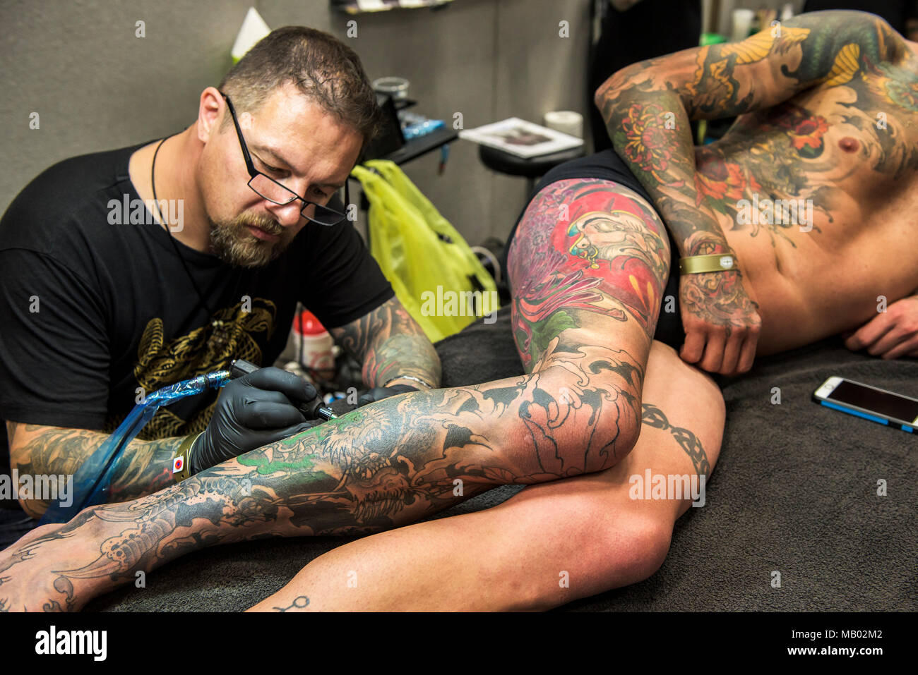 Luke Botterill tattooing a design on the leg of a customer at the Cornwall  Tattoo Convention Stock Photo - Alamy, image size:1300x957