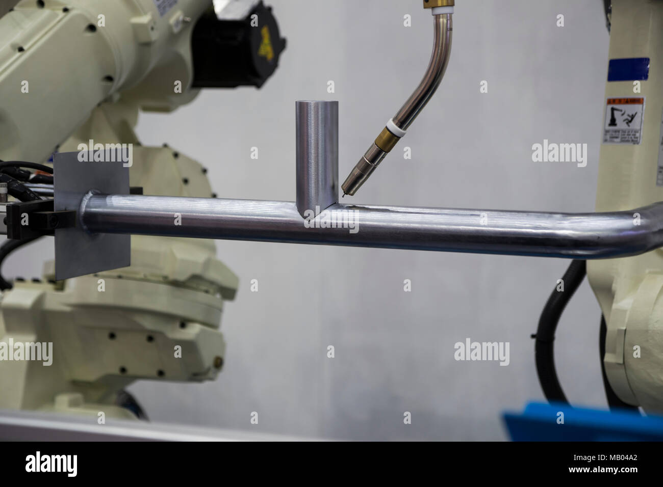 Robot arm welding pipe ; focus at torch Stock Photo