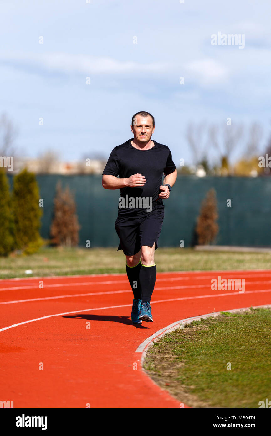 Male sprinter in middle age trains for race competition Stock Photo - Alamy