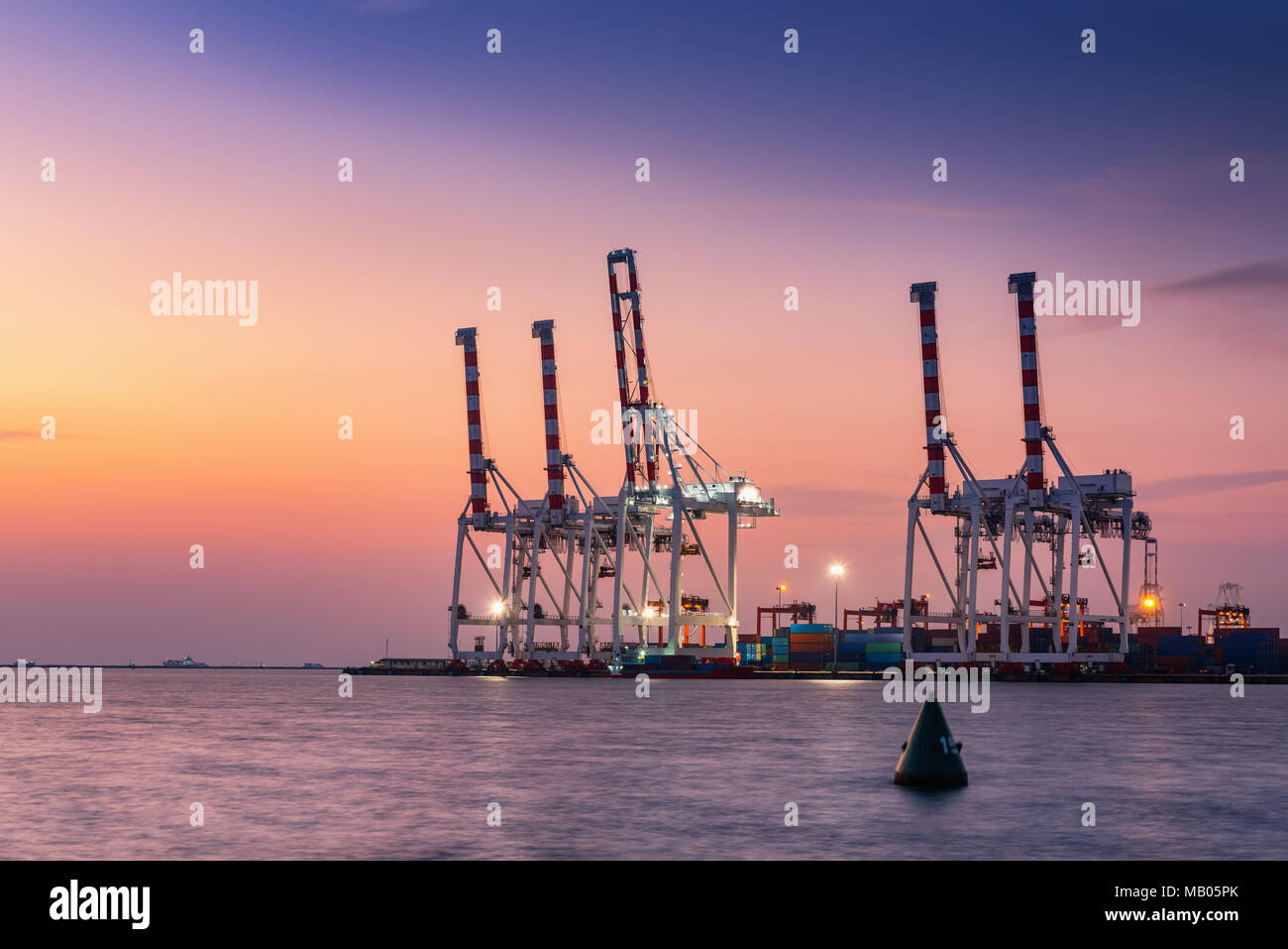 Cargo ship terminal at twilight scene, Unloading crane of cargo ship ...