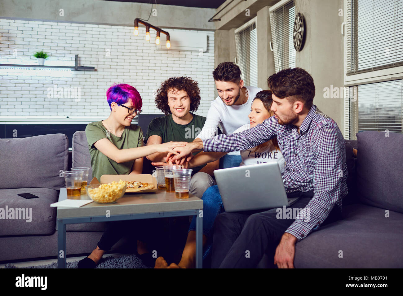 A group of friends of students in leisure with a laptop in a roo Stock Photo