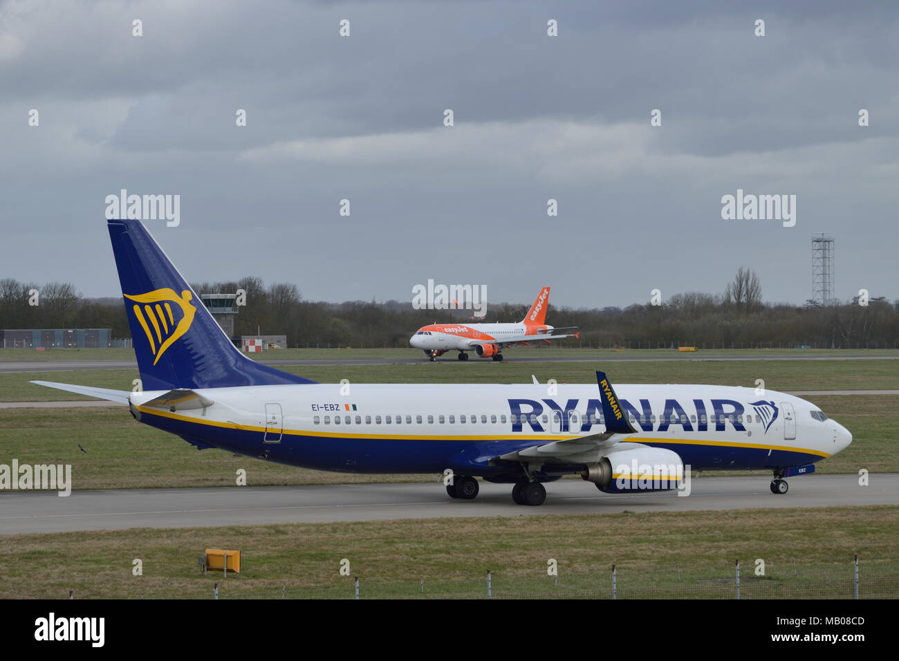 Ryanair aircraft taxiing in at London Stansted Airport as an Easyjet plane lands in the background Stock Photo