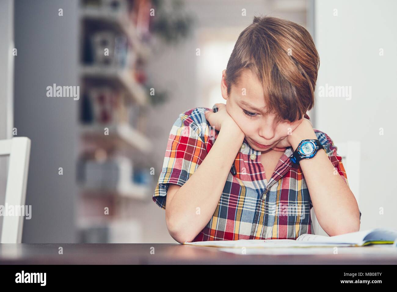 Learning at home. Little boy doing difficult math homework Stock Photo