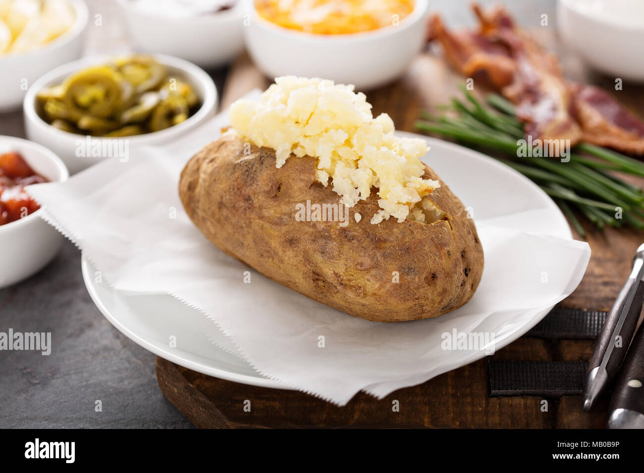Baked potato buffet with cheese, jalapenos, sour cream and bacon Stock