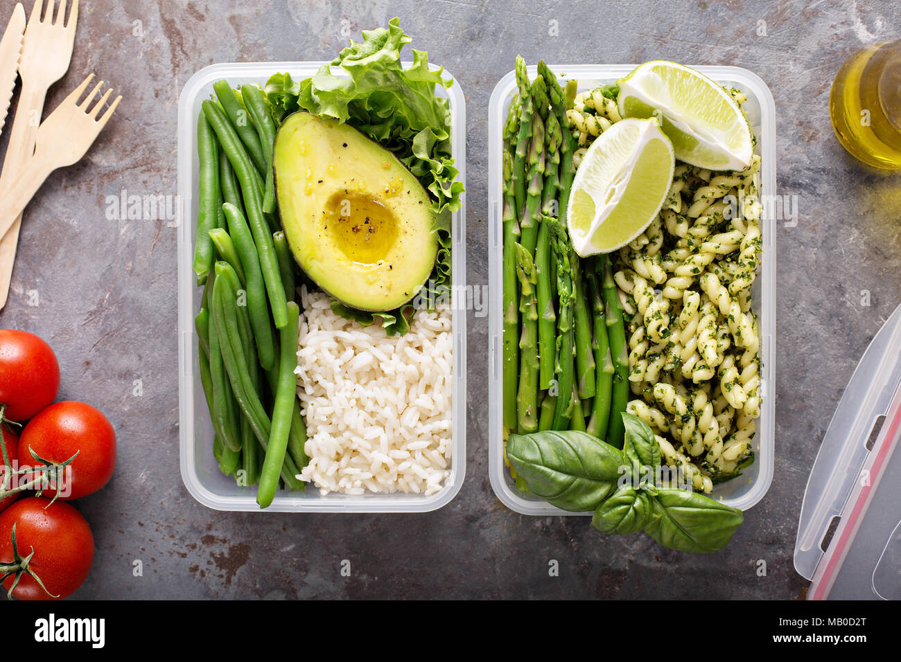 Vegan meal prep containers with rice and pasta with green pesto sauce and vegetables Stock Photo