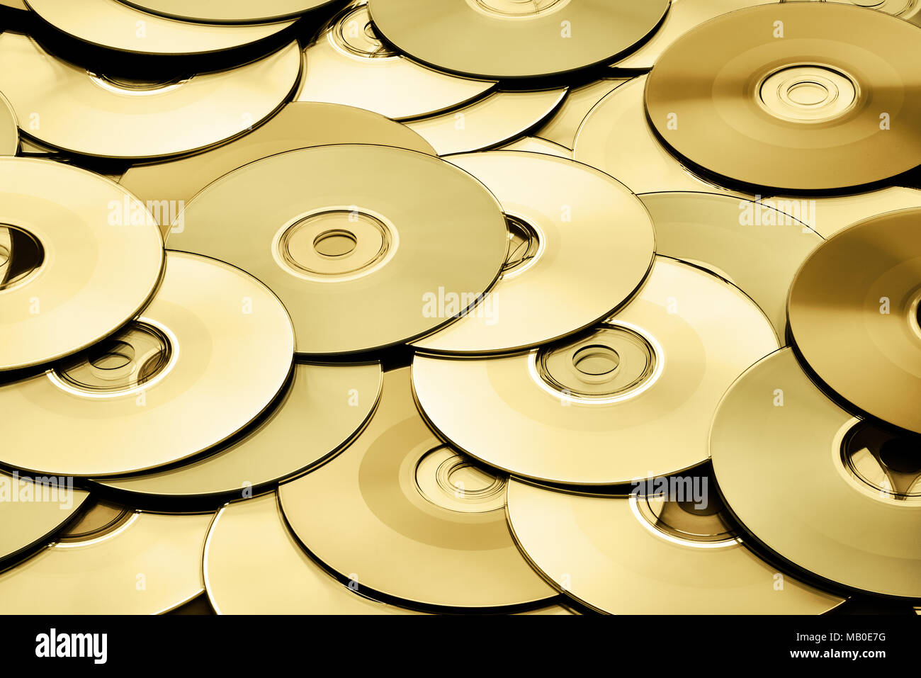 Random gold DVD and CD disks create data concept background Stock Photo