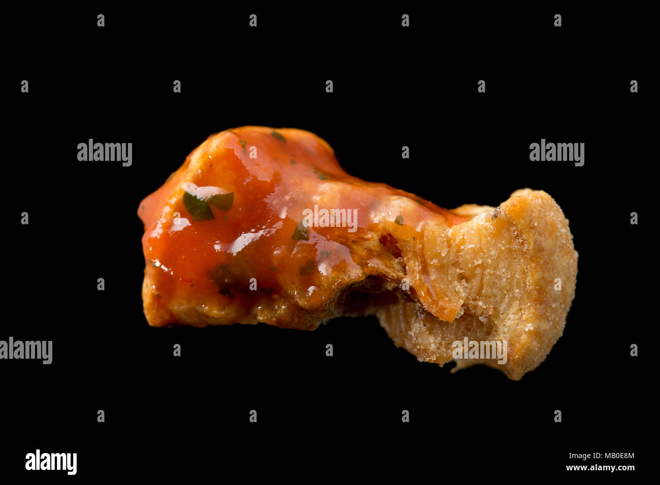 A pork scratching from a packet bought in a supermarket dipped in tomato and chilli salsa. UK Stock Photo