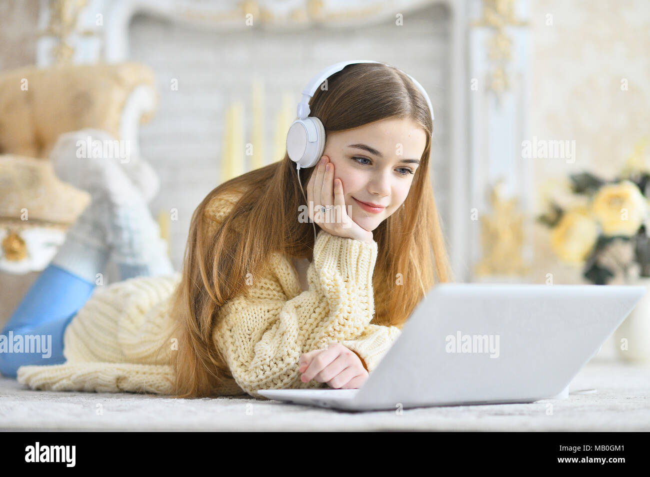 Beautiful teen girl lying on floor and using laptop Stock Photo - Alamy
