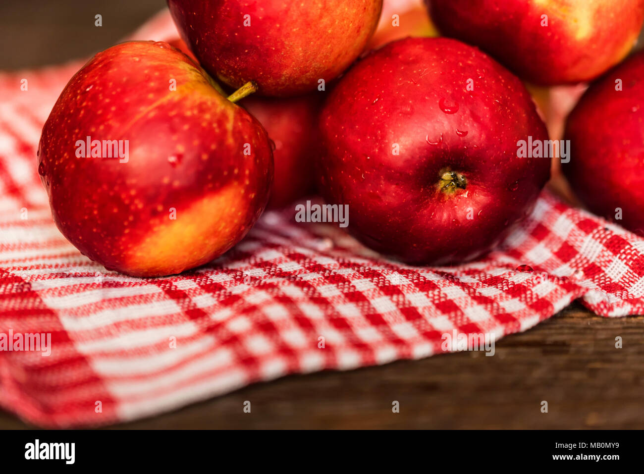 Whole ripe red apples on checked tablecloth close Stock Photo