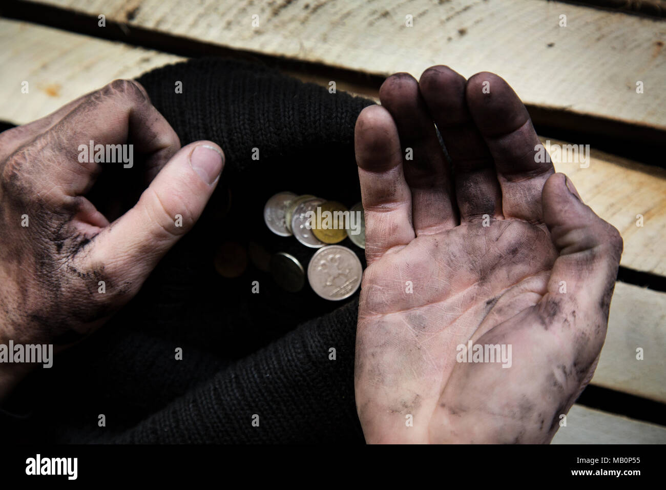 A beggar on the street is holding dirty hands with money Stock Photo