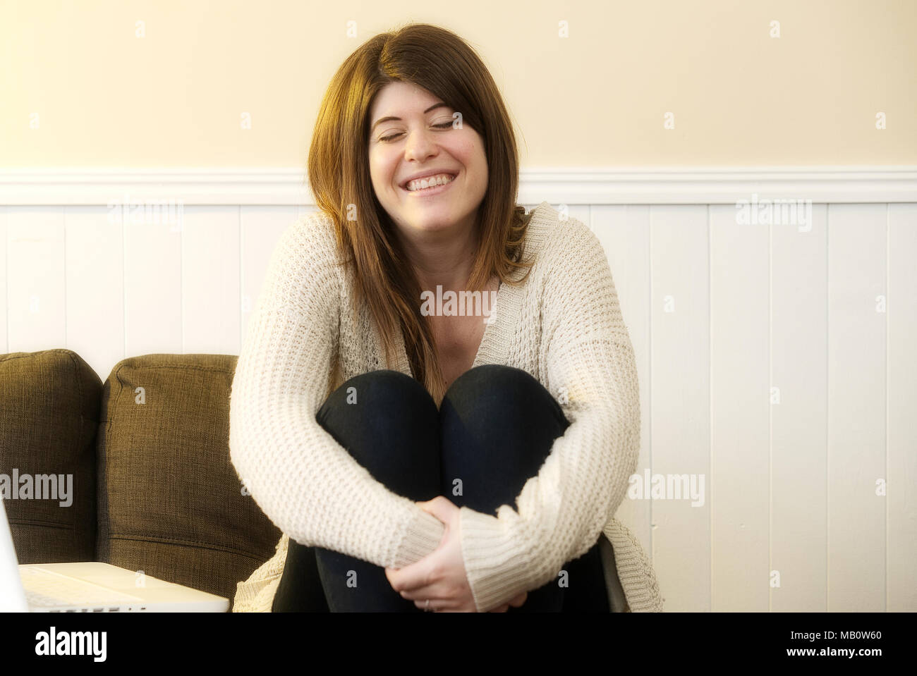 Repentigny,Canada,27,March,2018.Young woman sitting on couch smiling.Credit:Mario Beauregard/Alamy Live News Stock Photo