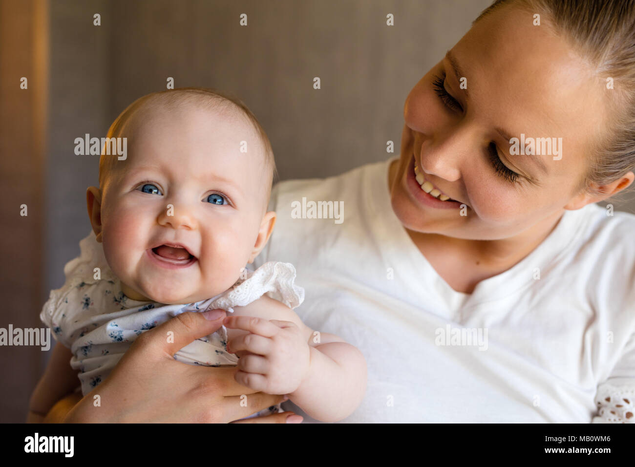 Smiling cute baby girl with her happy and caring mother Stock Photo