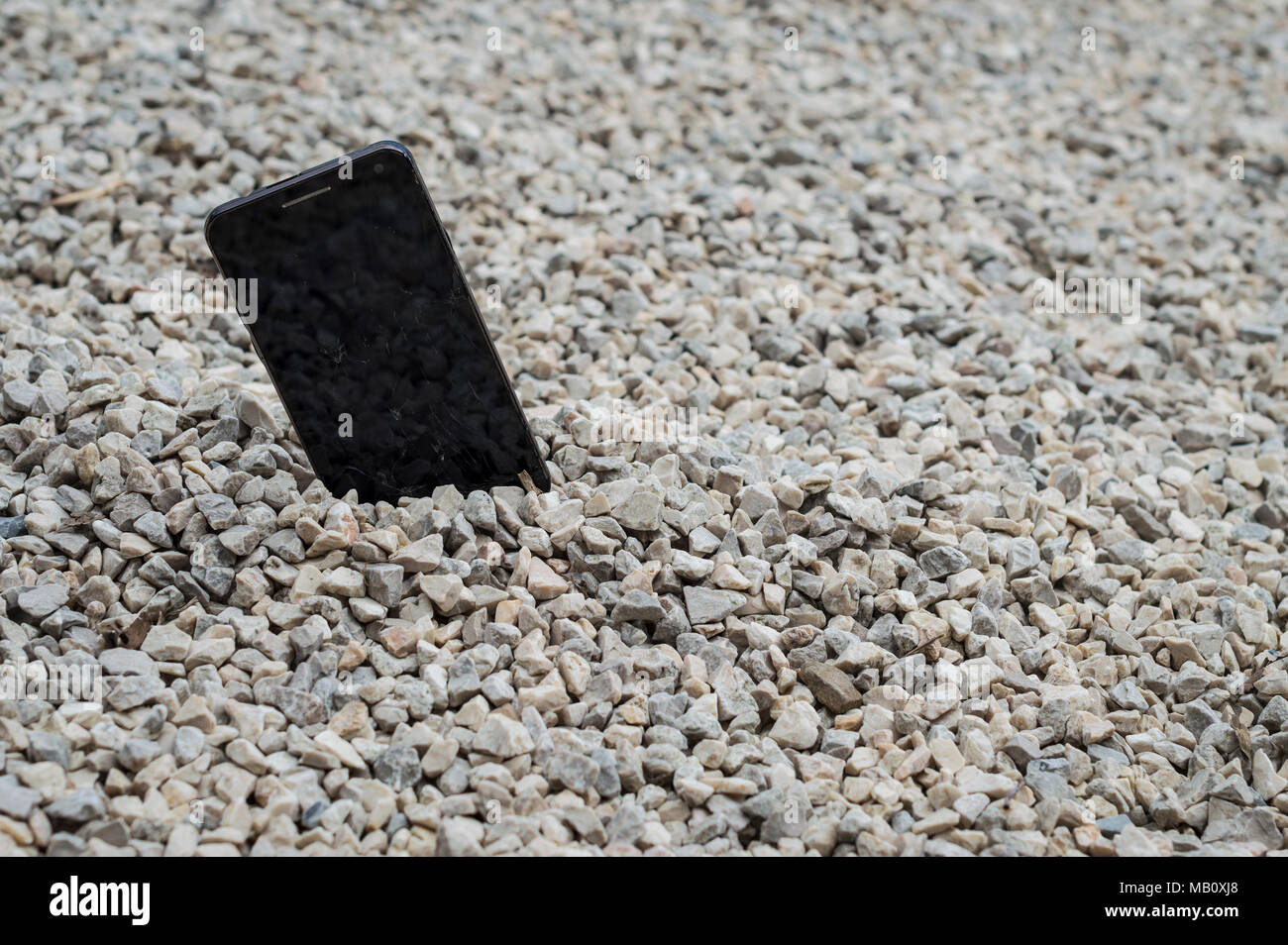 Broken smartphone abandoned and lost among the gravel Stock Photo - Alamy
