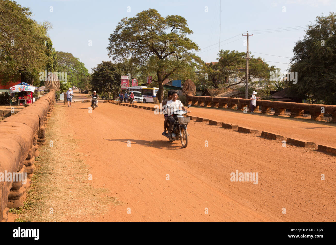 Motorbike crossing The Naga bridge, an ancient stone bridge, Kampong