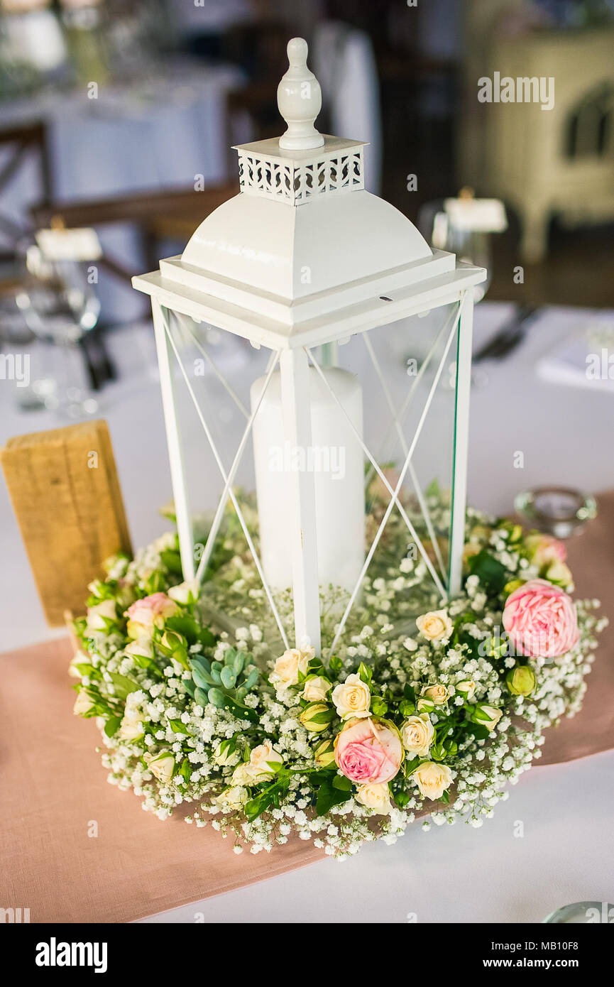 Romantic white candle lantern decorated with Baby's-breath (gypsophila) and pink roses Stock Photo