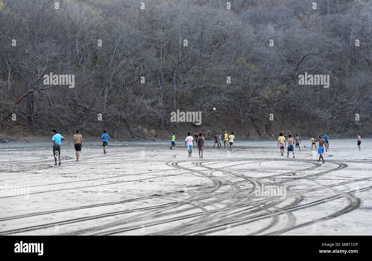 Football playing teenagers on the beach in Playa del Coco, Guanacaste province, Costa Rica Stock Photo