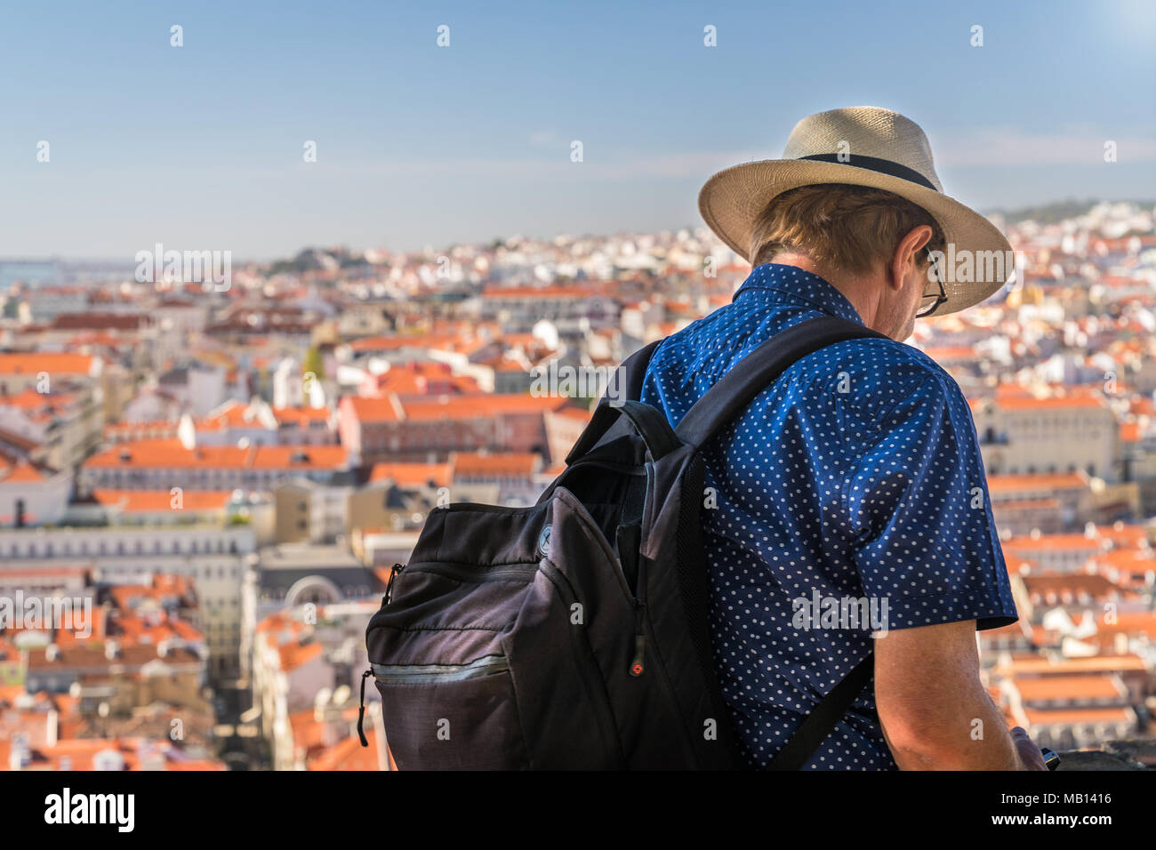 27 October 2017 - Lisbon, Portugal. Smartly dressed tourist is looking at scenic old town panorama of Lisbon. Stock Photo