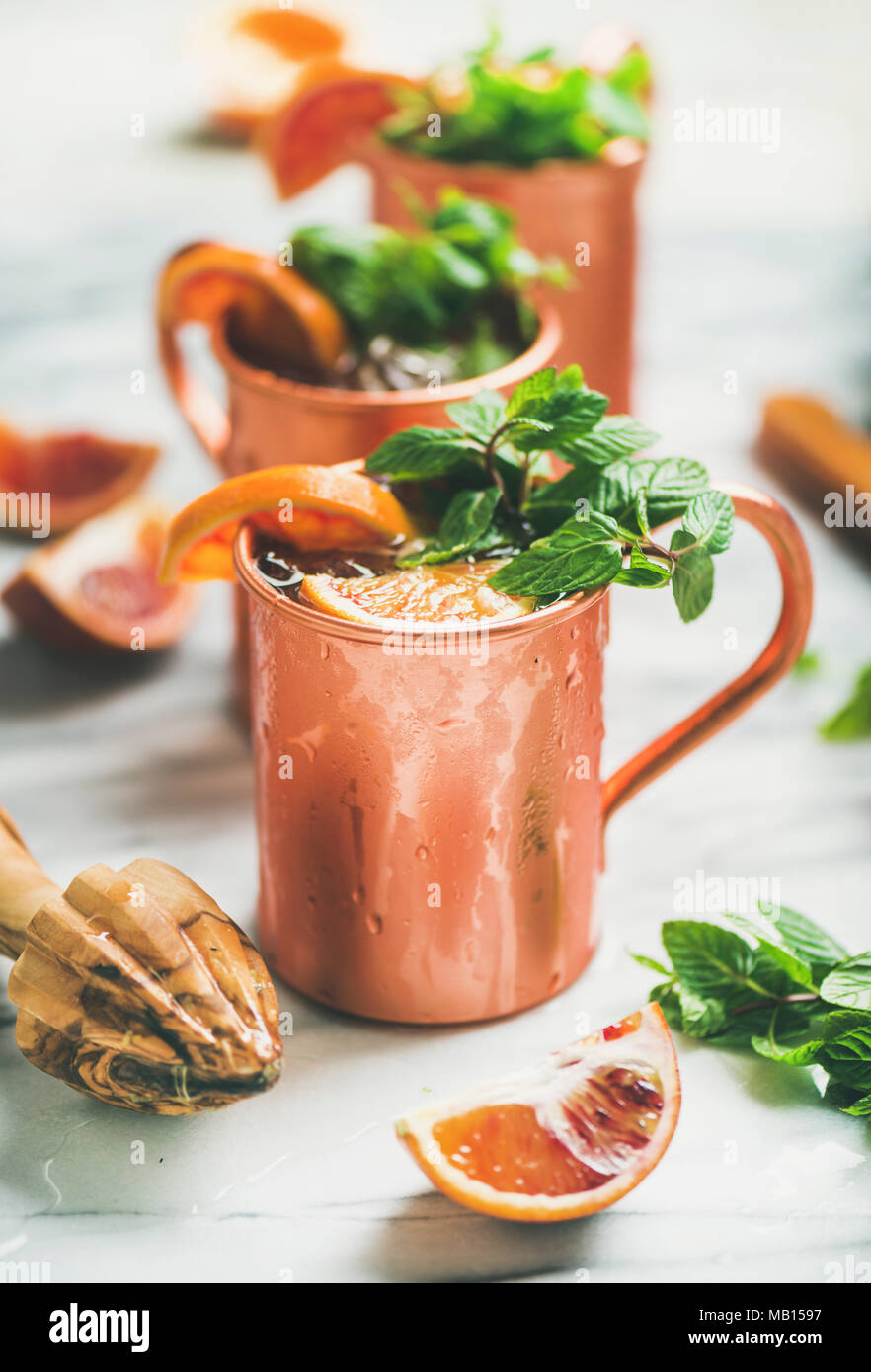 Blood orange Moscow mule alcohol cocktails with fresh mint leaves and
