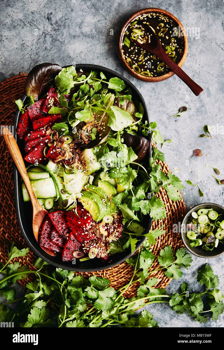 Asian red dragon fruit vegetarian salad. topped with fried spring onions and a asian dressing. Stock Photo