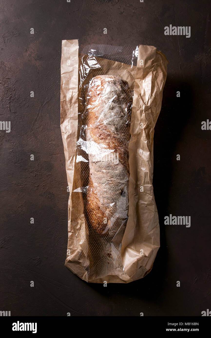 Loaf of fresh baked artisan whole grain ciabatta bread in market paper ...