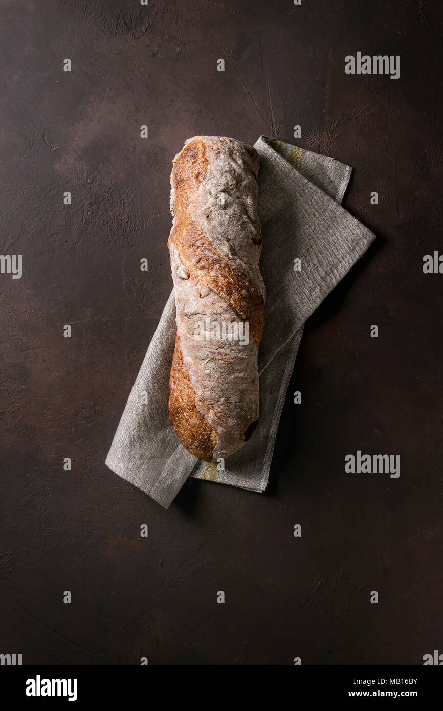Loaf of fresh baked artisan whole grain ciabatta bread on linen cloth ...