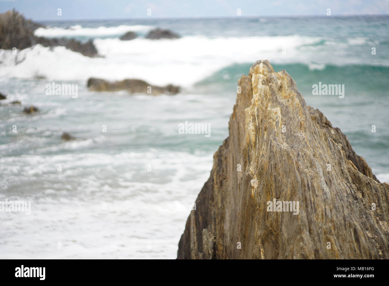 Big rock in the sea with waves Stock Photo - Alamy