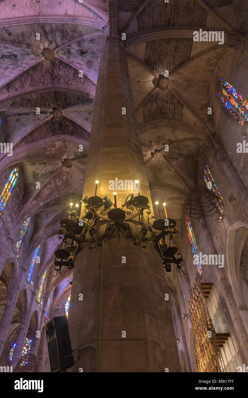 Eine Säule mit Kerzenleuchter im Hauptschiff von La Seu - der Kathedrale in Palma de Mallorca - mit Blick auf die Gewölbedecke Stock Photo