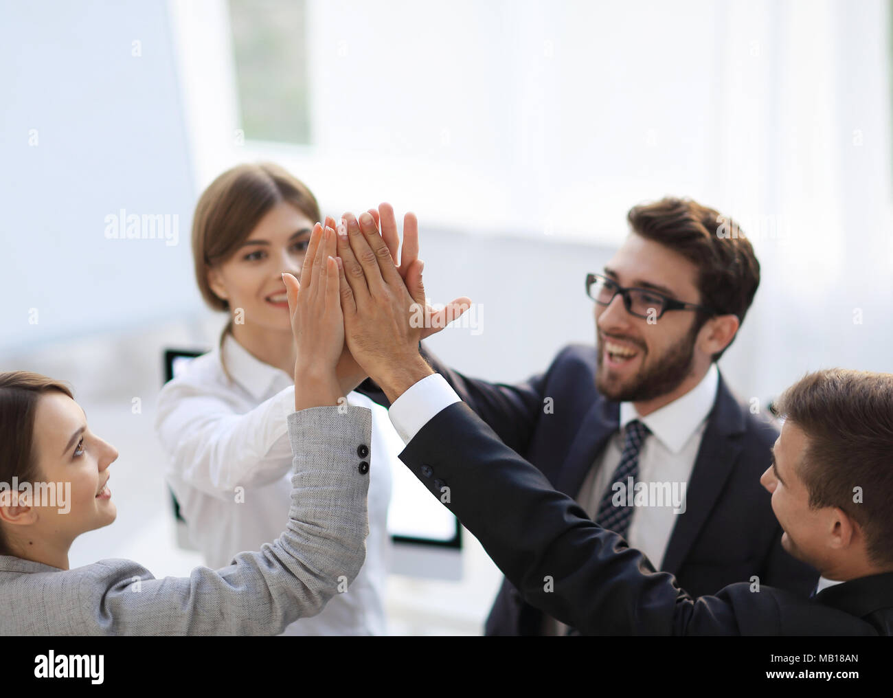 successful business team giving each other a high-five, standing in the ...