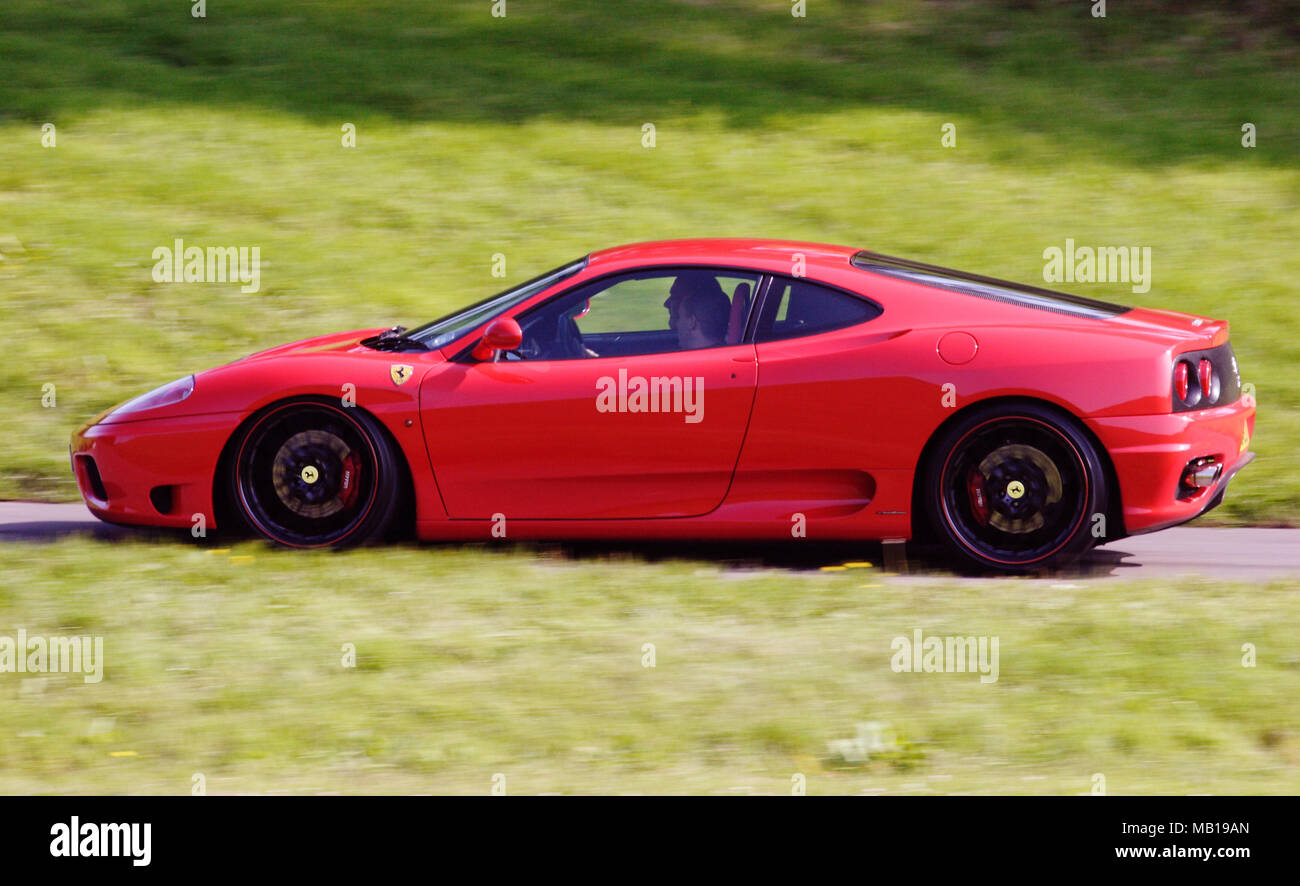 Red Ferrari 360 super car supercar in profile (side view) and driving fast. Stock Photo