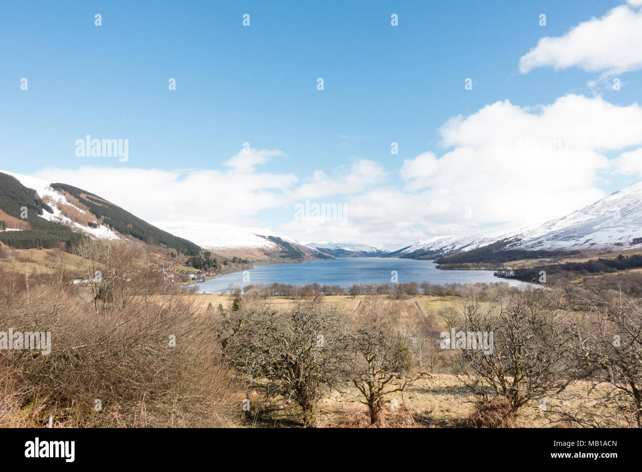 Loch Earn landscape after an early spring snowfall, with Lochearnhead village at the western end - view from the Rob Roy Way footpath, Scotland, UK Stock Photo