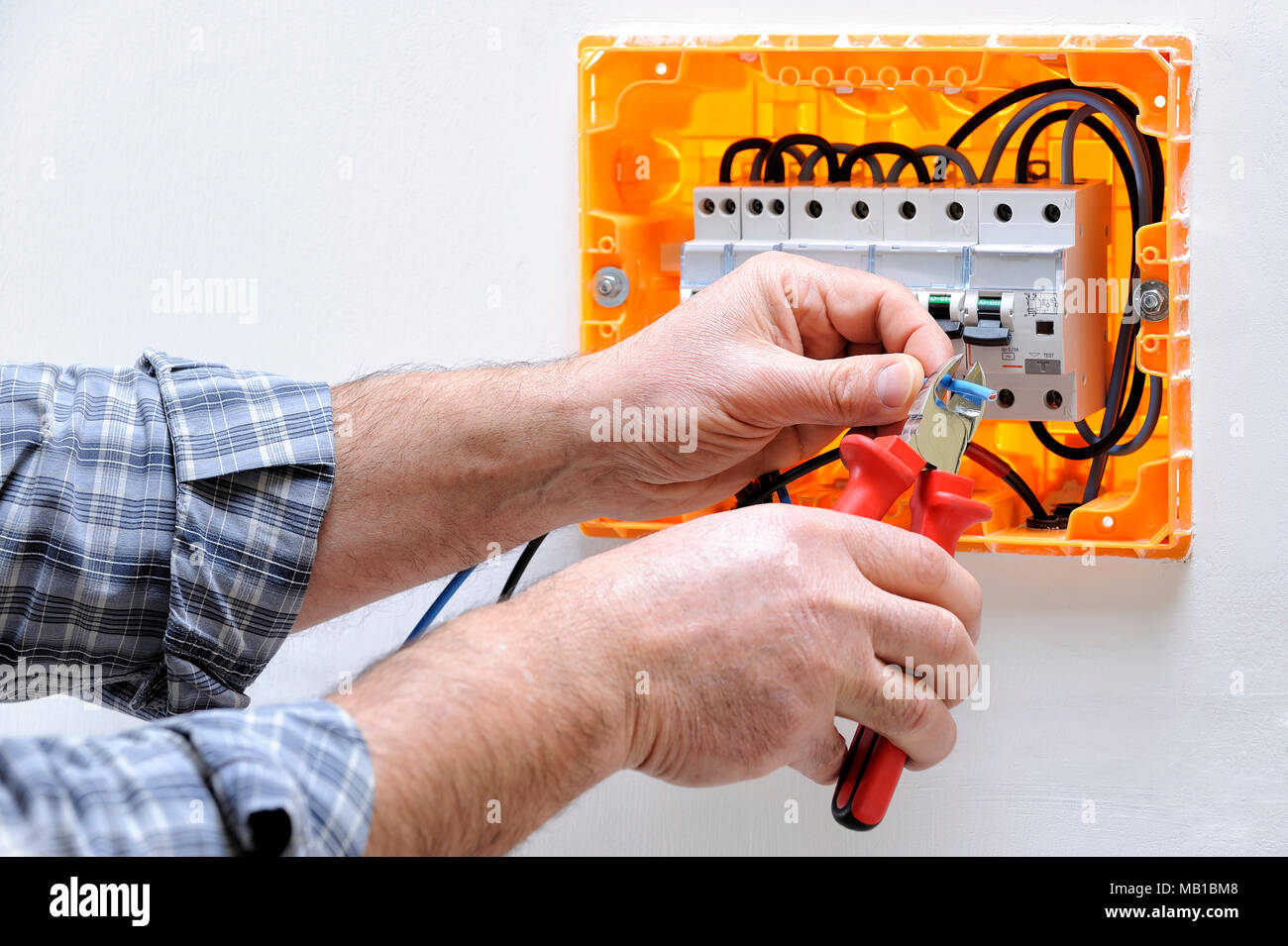 Electrician technician working on a residential electric panel, cuts