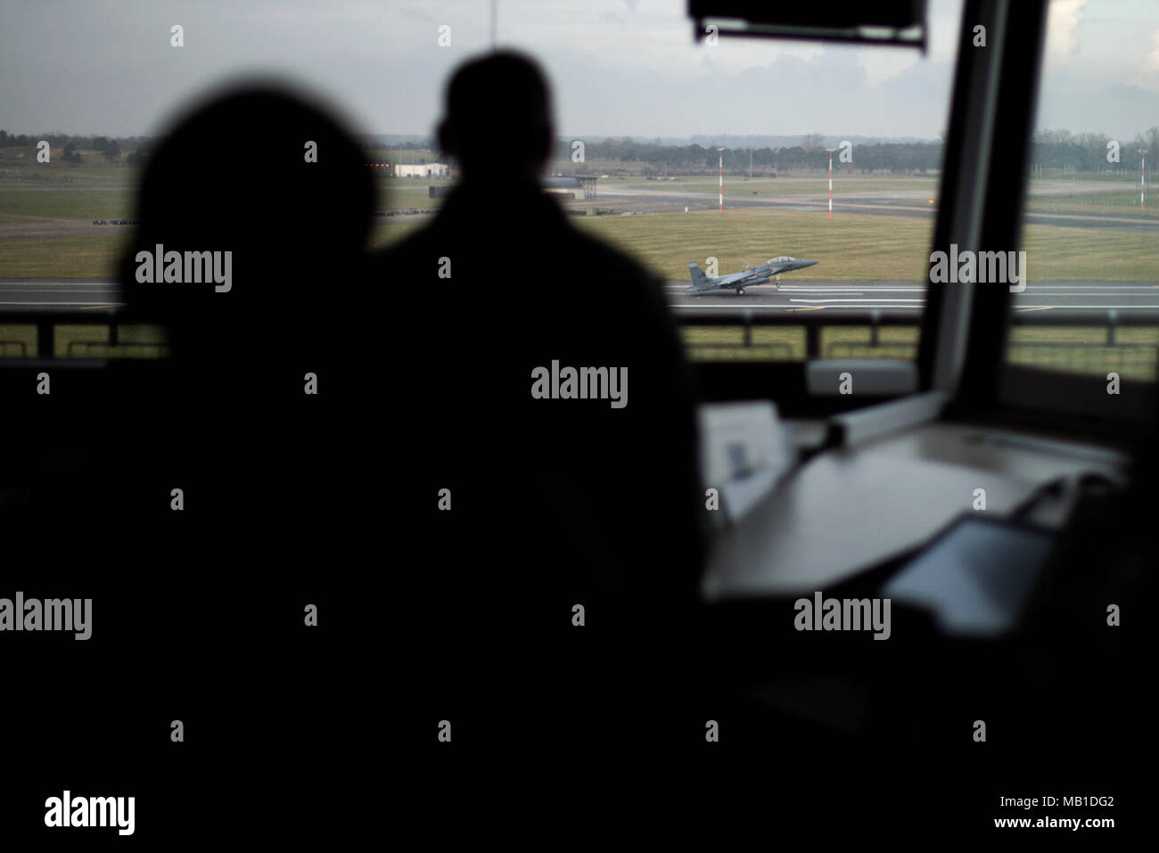 Airmen from the 48th Operations Support Squadron air traffic control tower watch as an F-15E lands at Royal Air Force Lakenheath, England, Feb. 6, 2017. The tower controls all air traffic in and out of the base. Stock Photo