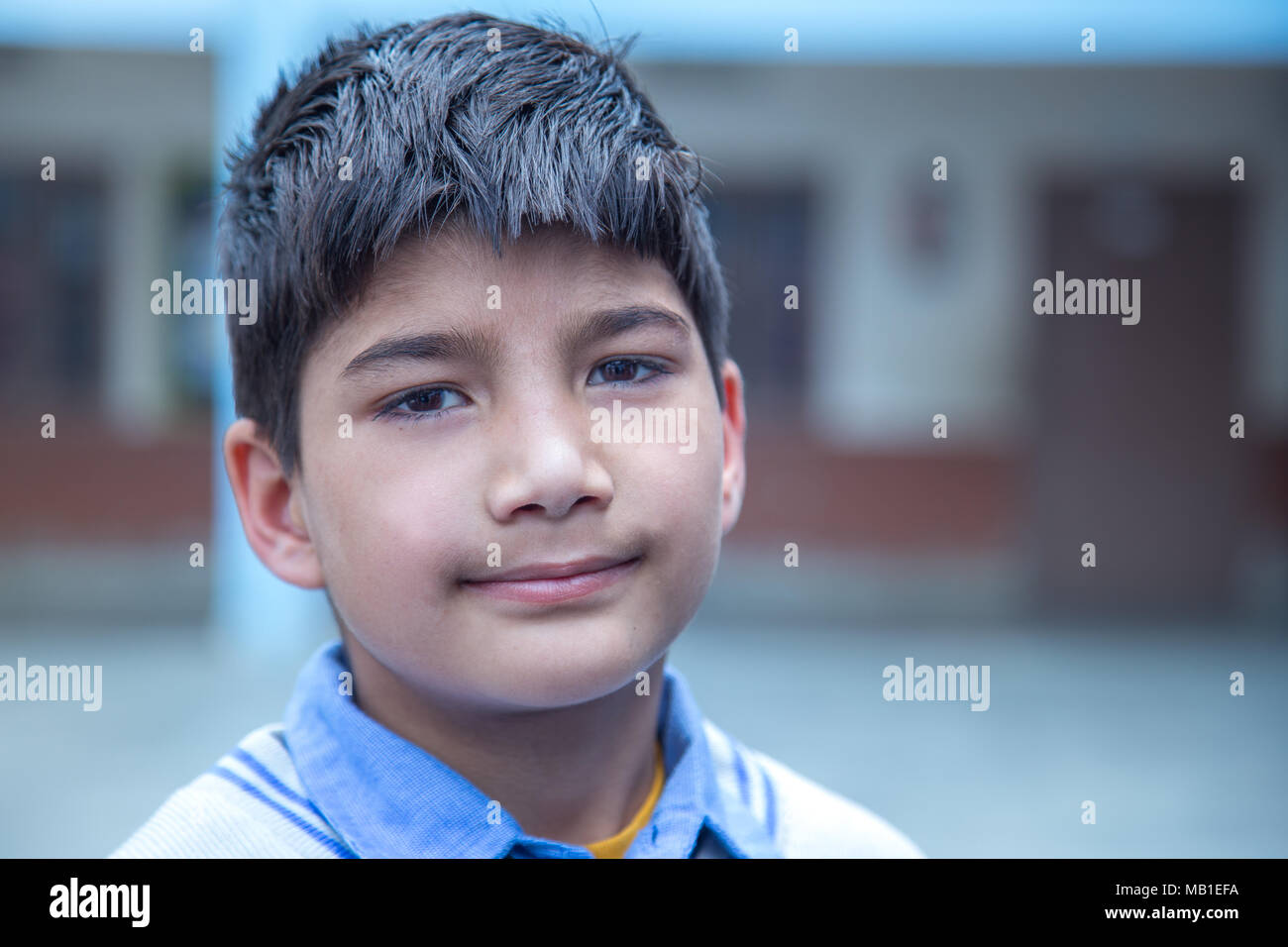 Closeup portrait of smiling 8-9 years Indian kid, standing straight at school campus in school uniform and looking at camera Stock Photo