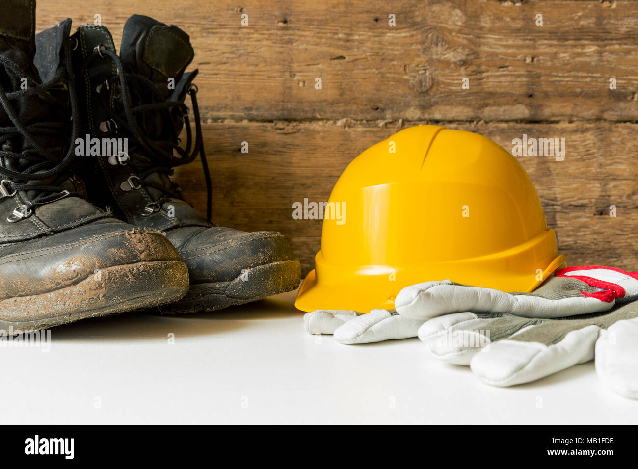 Equipment safety standard. Yellow hard hat, construction boots and gloves. Stock Photo