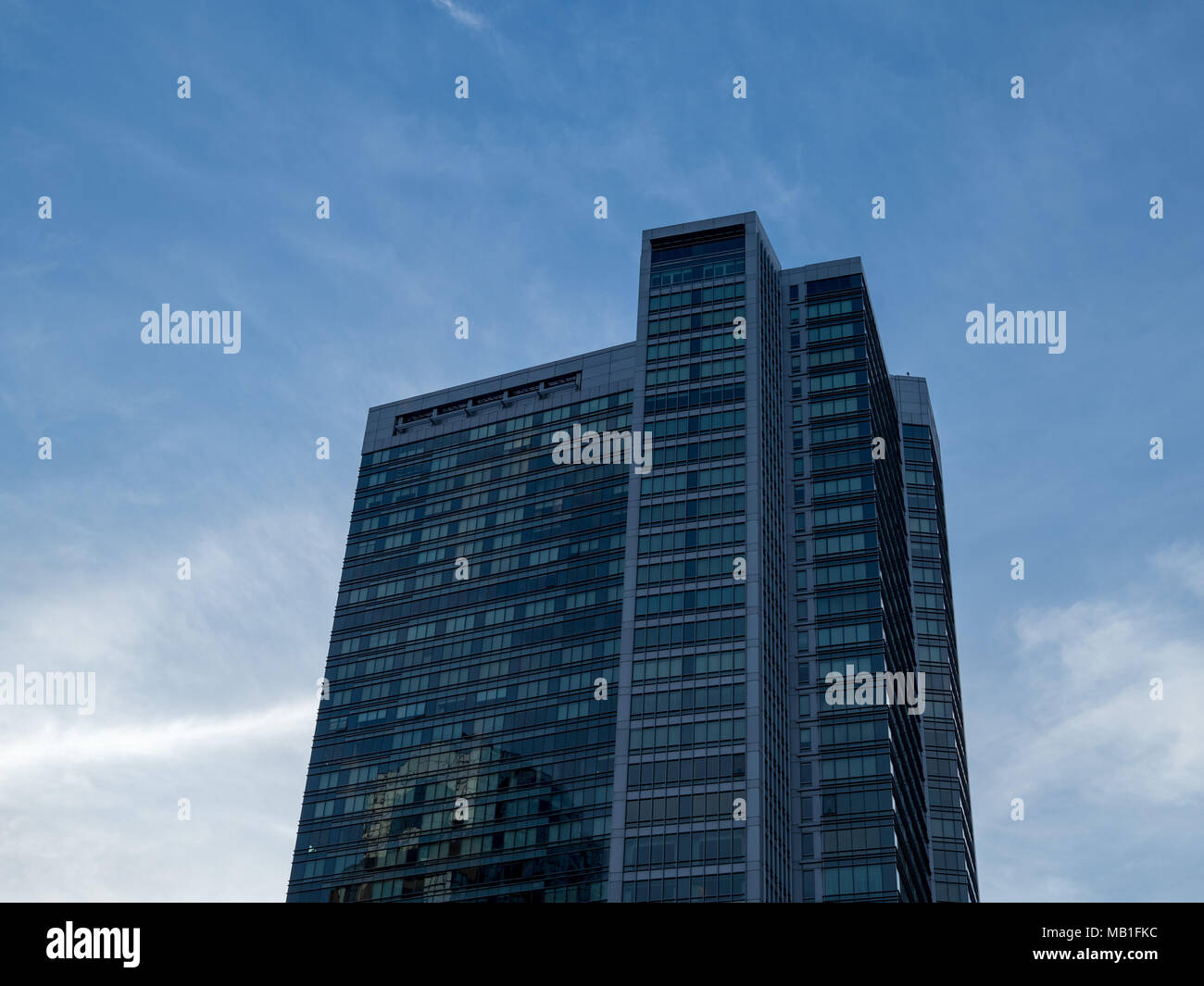 Modern high rise building at dusk. Sun setting, other buildings ...