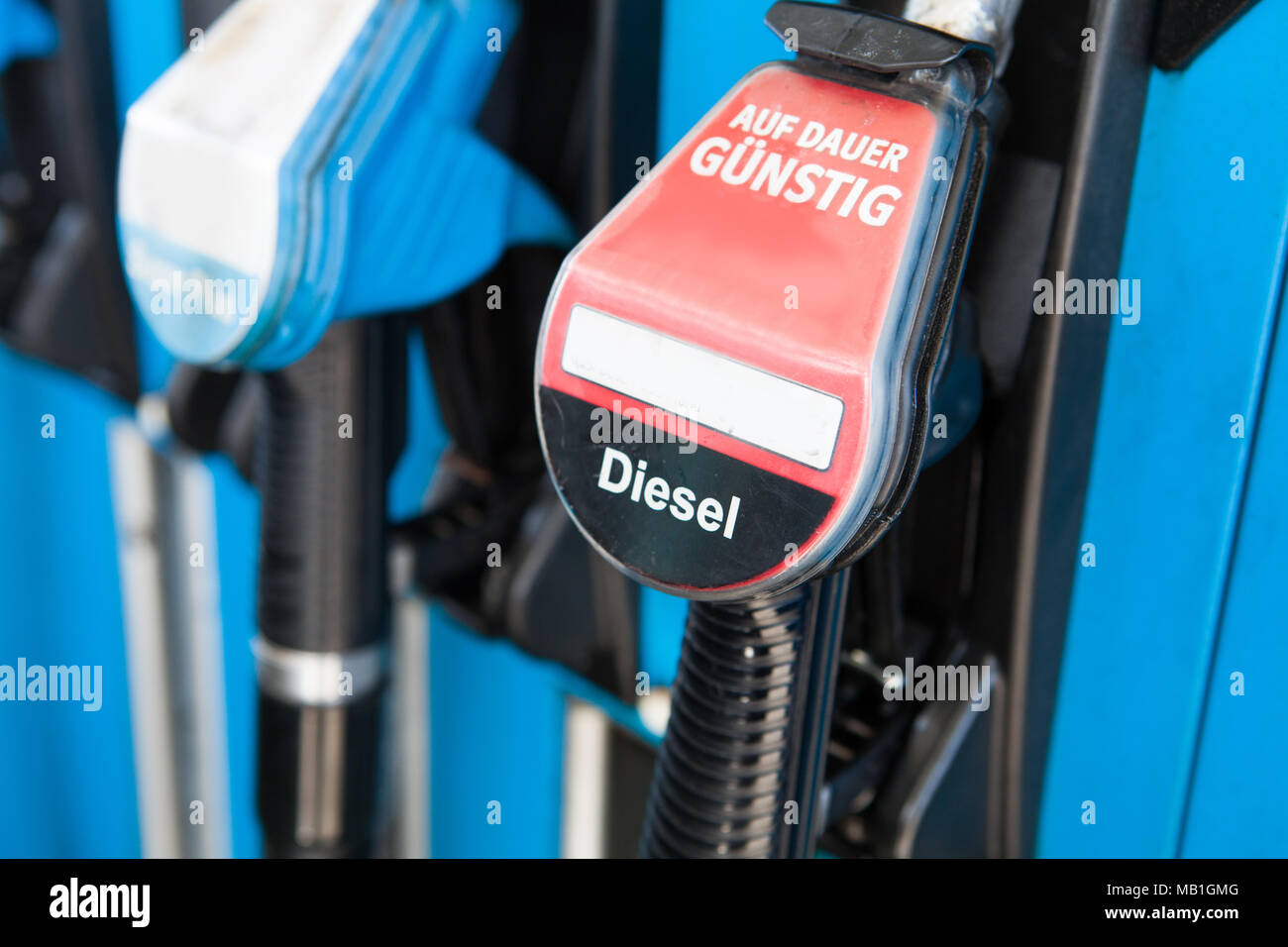 Diesel fuel pumps at petrol station with german text „Auf Dauer günstig“ means always cheap. Stock Photo