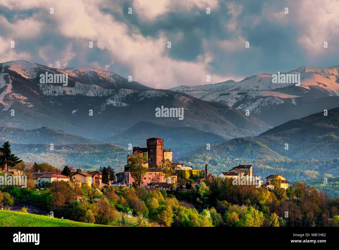 The village of Ciglié with its medieval castle, in the Langhe, in Piedmont. In the background the Maritime Alps and the mount Mindino. Stock Photo