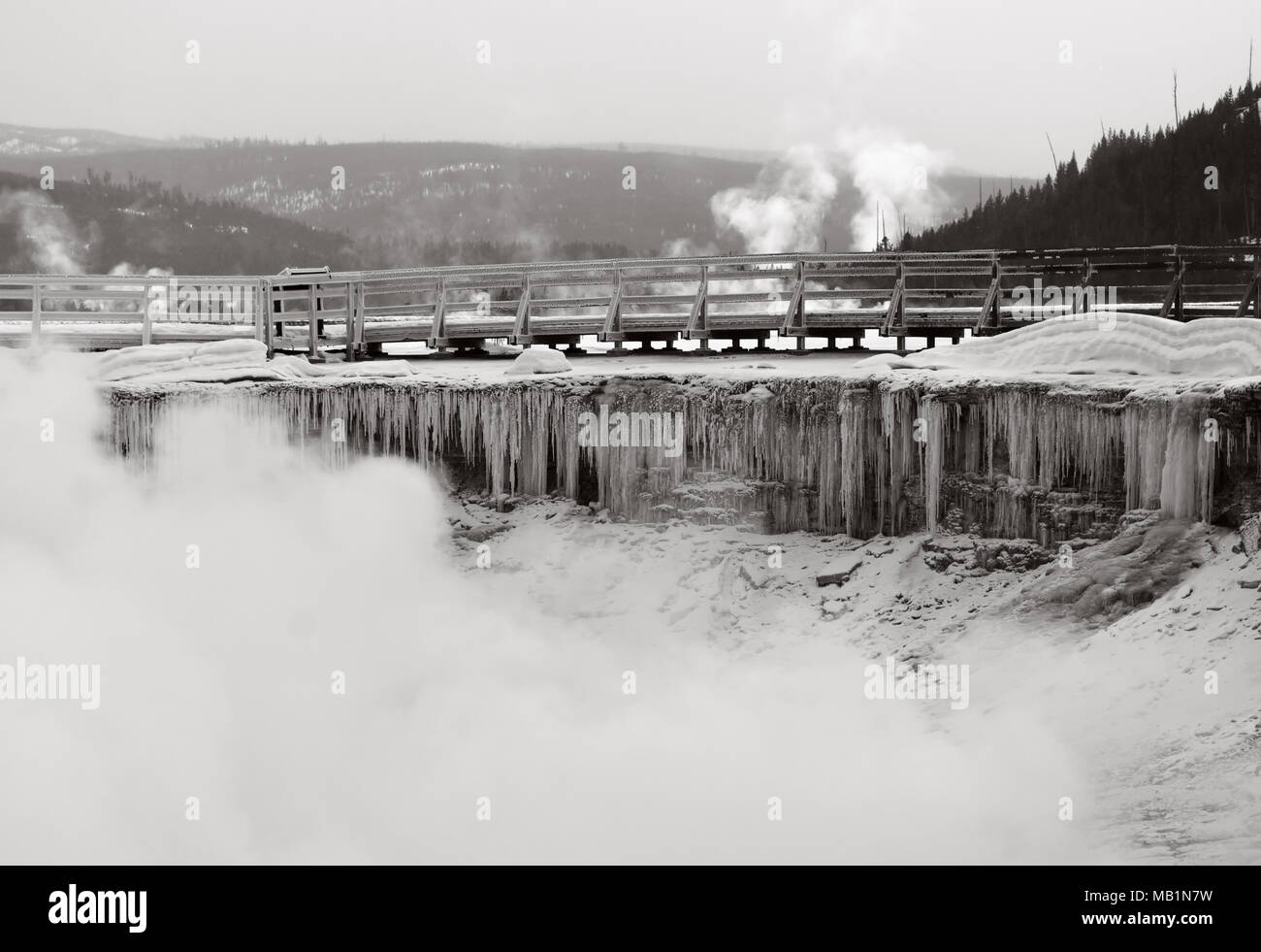 With temperatures below freezing, the boardwalk at a Yellowstone geyser is coated in layers of ice. Stock Photo