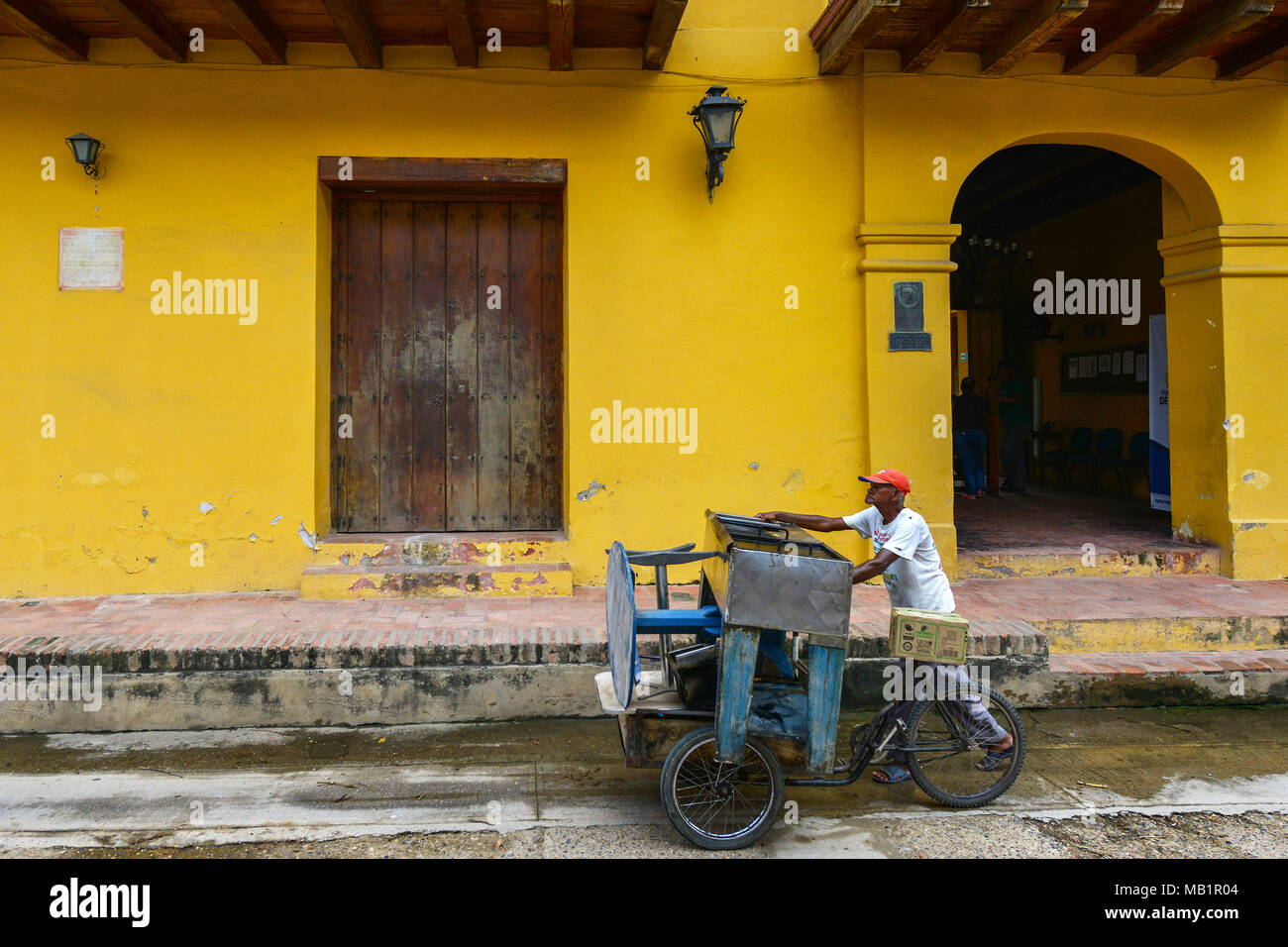 Mompox, Colombia - August 8, 2017: An unidentified man on a tricycle down a street in Mompox, Colombia. Stock Photo