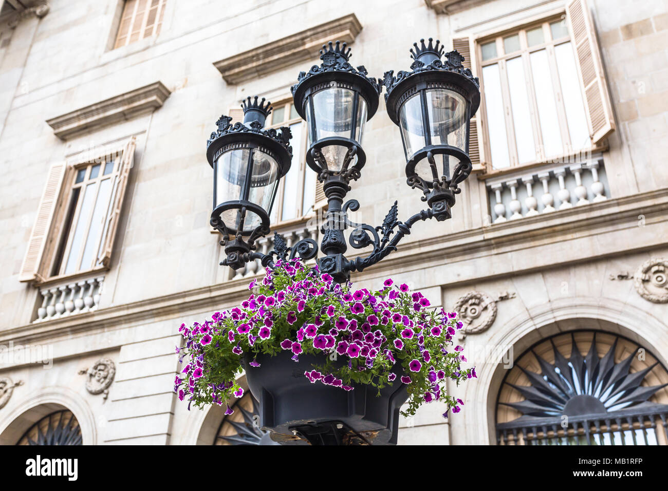 Iron and glass lanterns adorned with brightly colored flowers Stock Photo