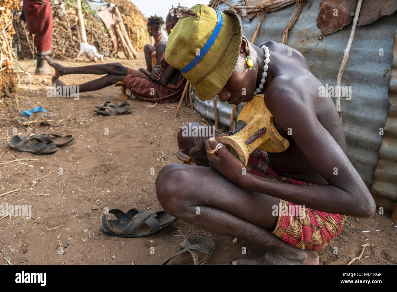Omorate, Ethiopia - January 25, 2018: Unidentified men from the Dassanech tribe making chairs in their village in Omorate, Ethiopia. Stock Photo