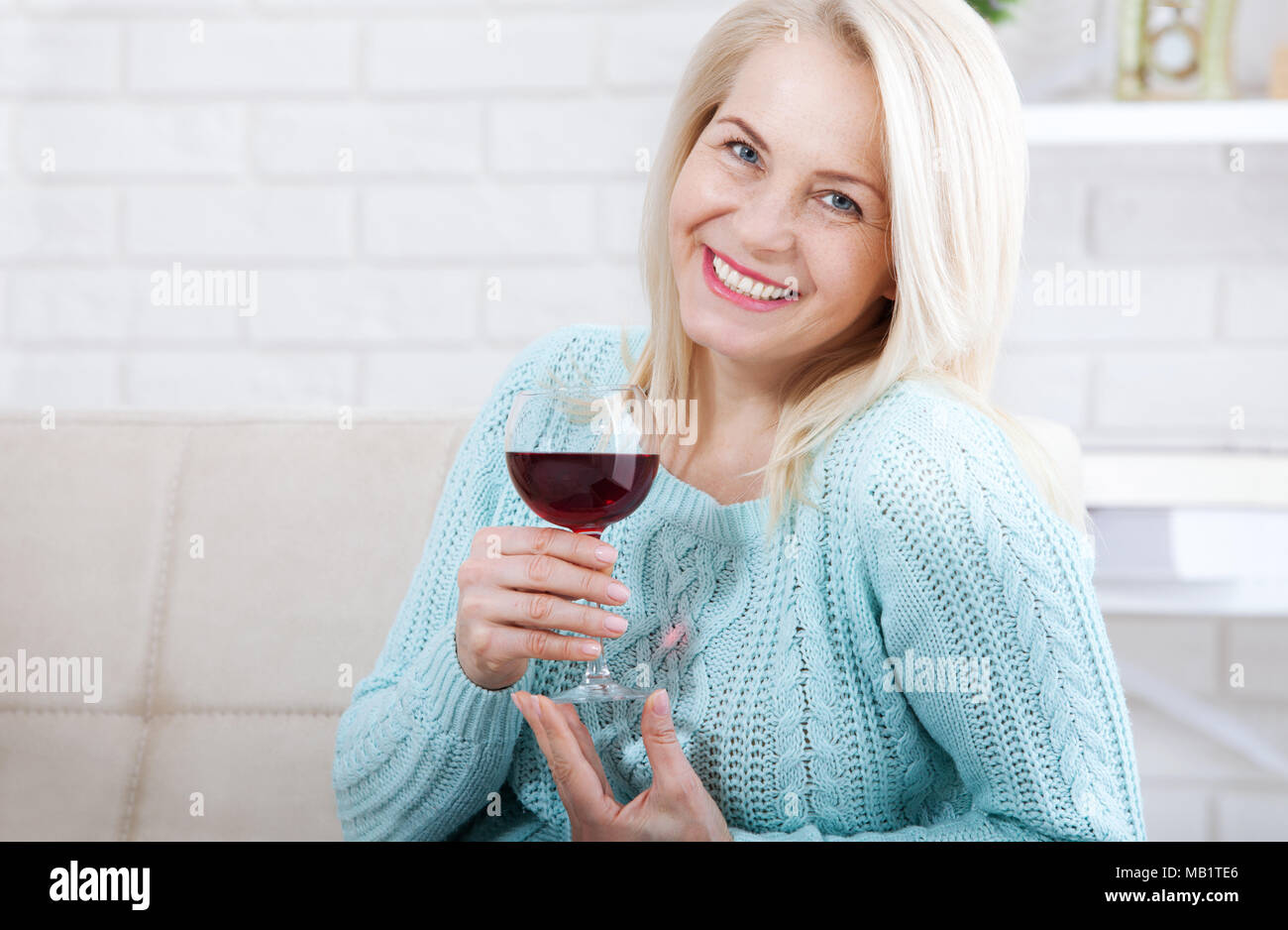 Happy blonde drinking red wine with eyes closed. Stock Photo