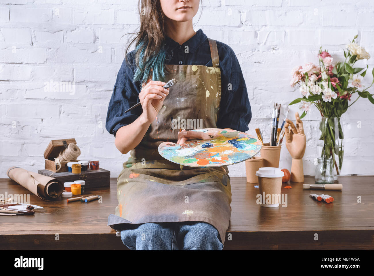 cropped image of artist holding palette and brush Stock Photo