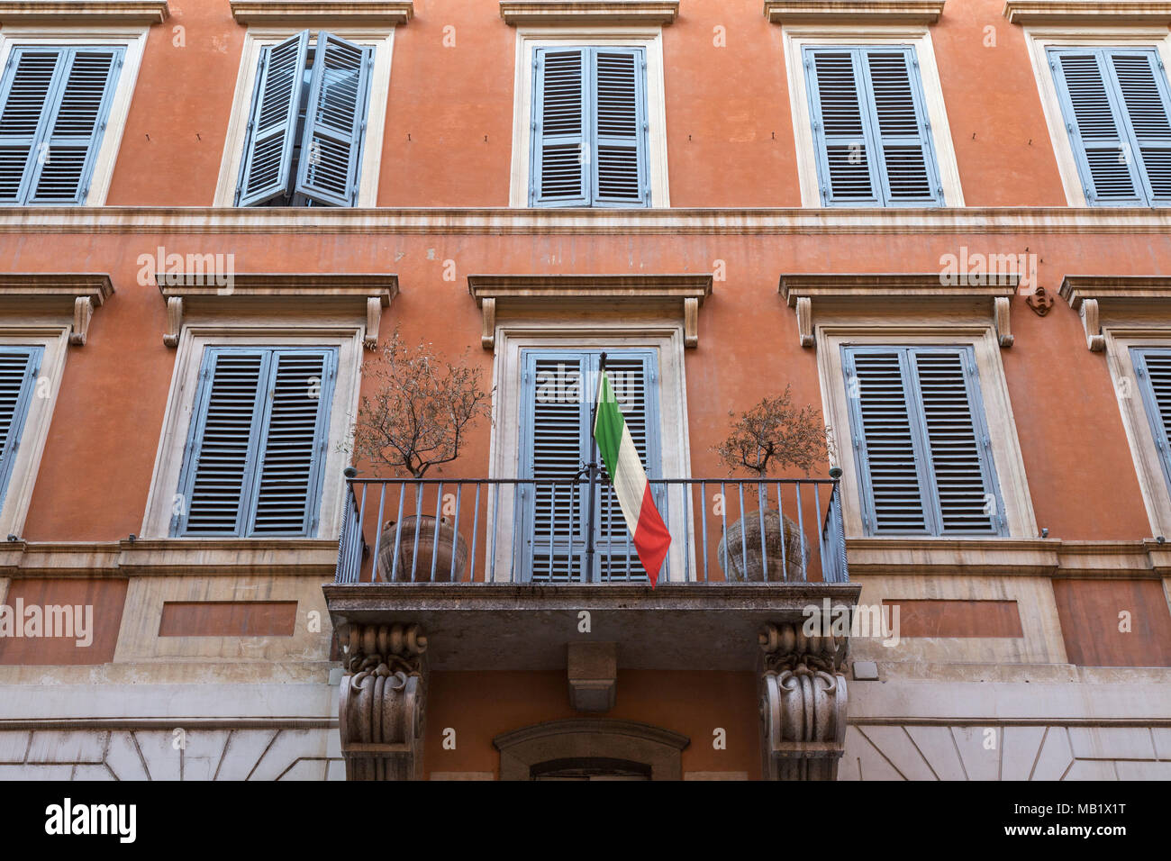 Looking up at a balcony displaying the Italian flag on a building in Rome, Italy. Stock Photo