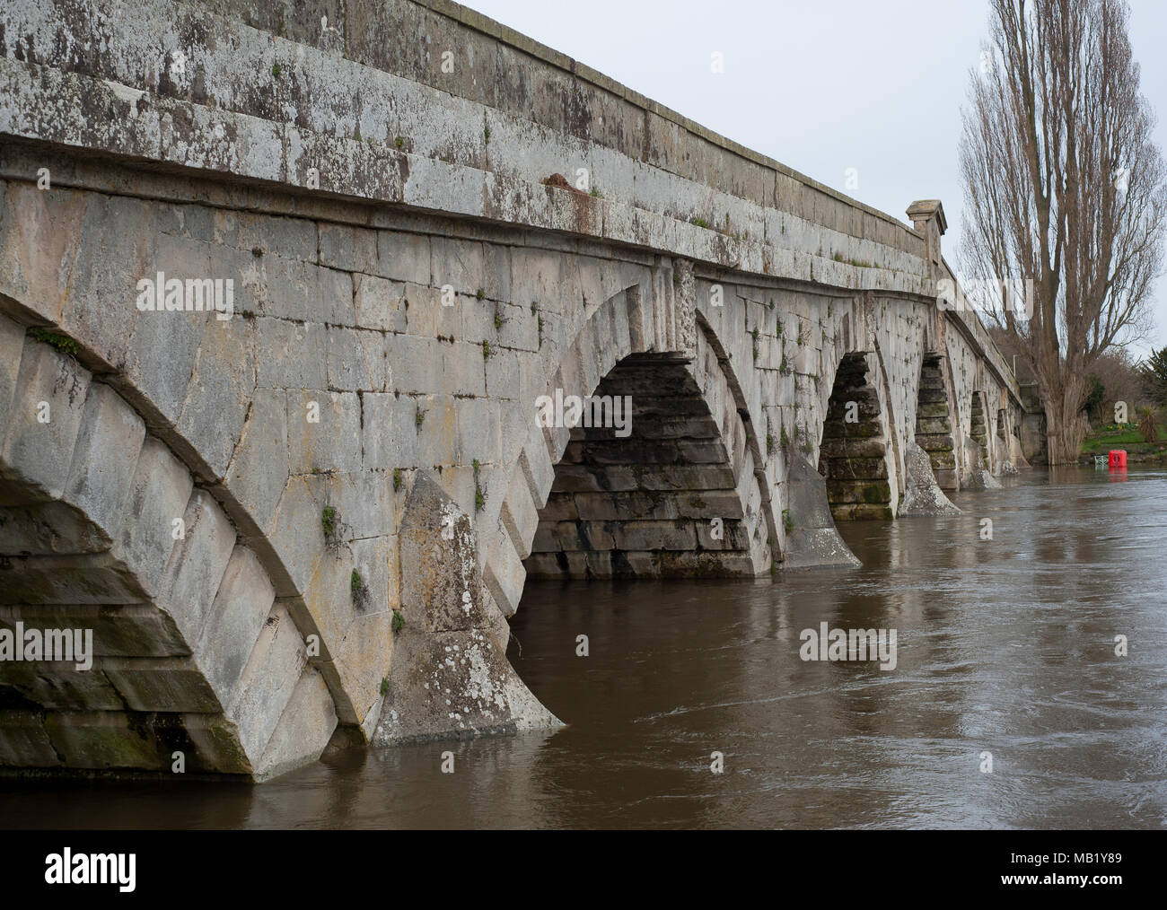 Historic 18th century footbridge and 20th century road bridge at Atcham, Shropshire, England over flooded River Severn in springtime Stock Photo