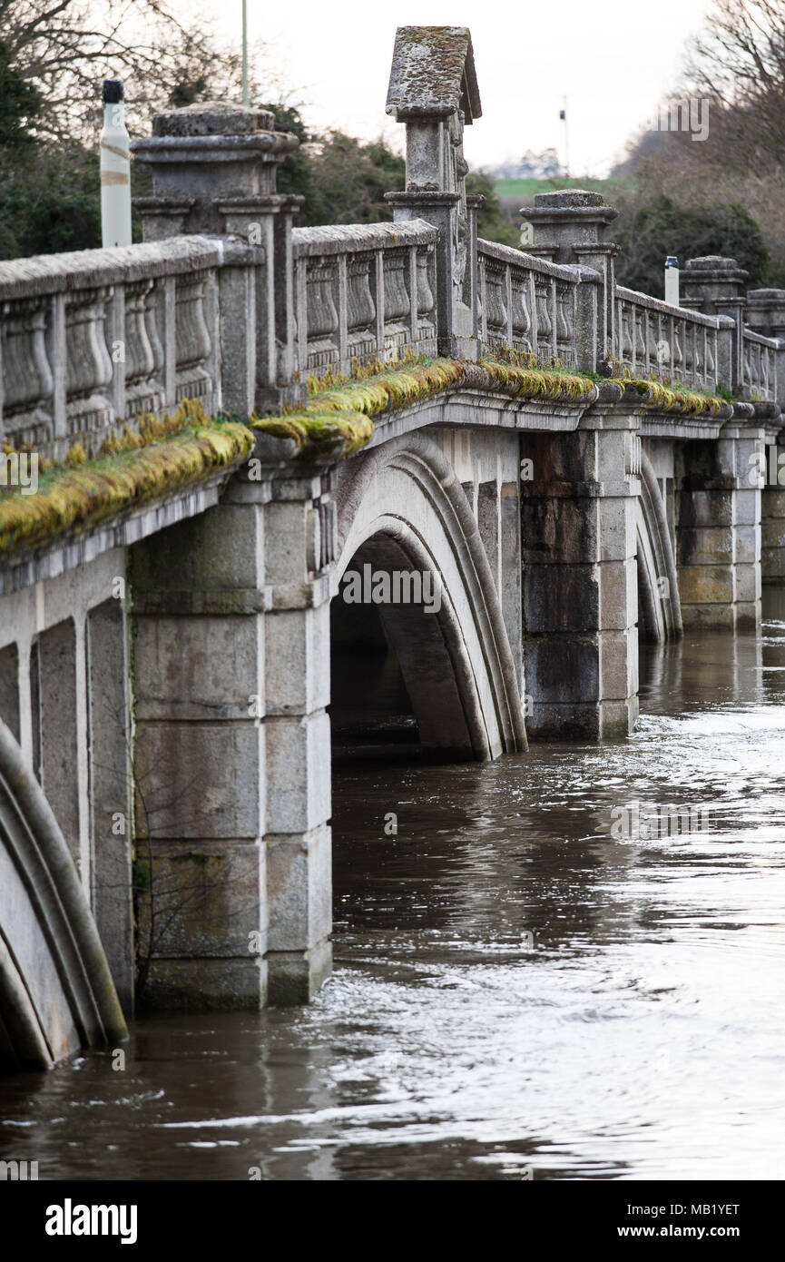 Historic 18th century footbridge and 20th century road bridge at Atcham, Shropshire, England over flooded River Severn in springtime Stock Photo