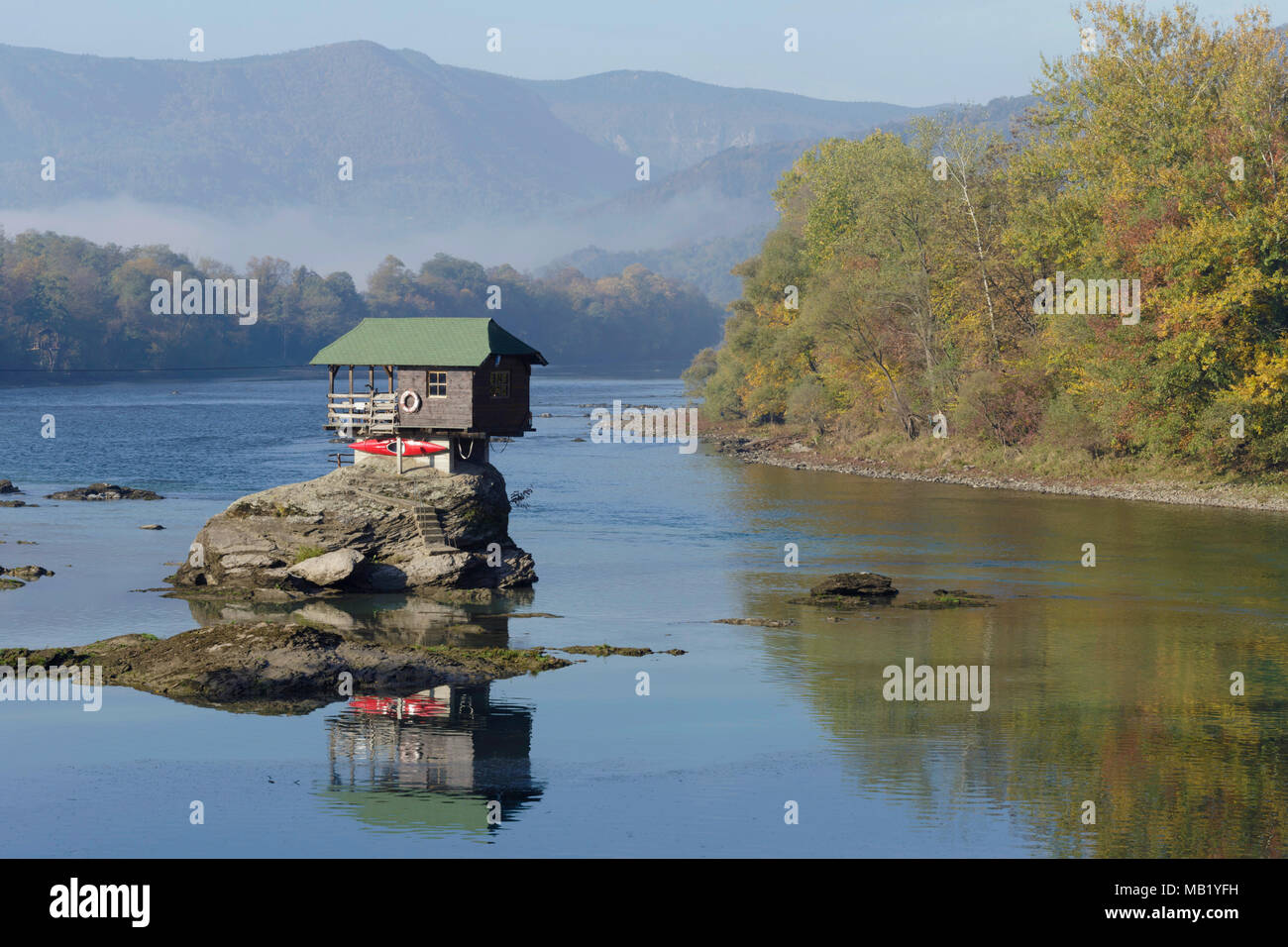 The house on the River Drina, with trees in Autumn colour and distant mountains, Bajina Basta, Serbia, October Stock Photo
