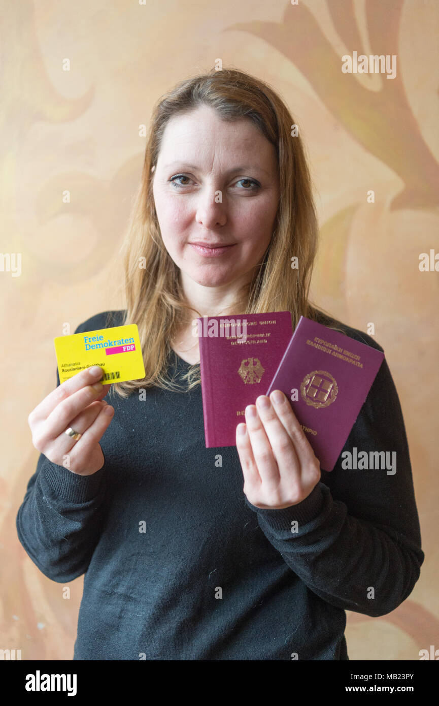 20 March 2018, Germany, Berlin: Athanasia Rousiamani-Goldthau of the Free Democratic Party (FDP), a politican from Greece, holds up her German and Greek passports and her FDP member's card. She joined the German FDP in her youth despite only having a Greek passport. Photo: Christophe Gateau/dpa Stock Photo